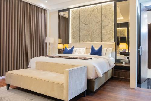 a bedroom with a large bed with blue pillows at BEST WORLD KINDAI HOTEL in Banjarmasin