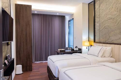 a hotel room with two beds and a window at BEST WORLD KINDAI HOTEL in Banjarmasin