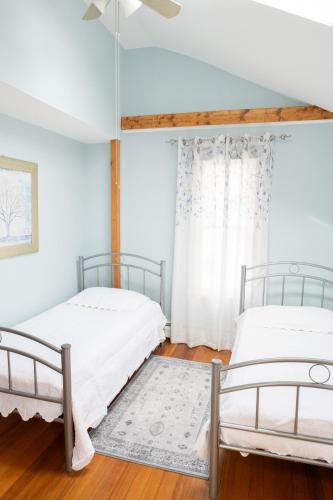 two beds in a room with white walls at Modern Beautiful Apartment-5 Beds-Full Kitchen-Parking-Super Clean-Great for Groups in Boston