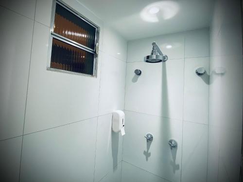 a white bathroom with a shower with a window at Sun Smart Hotel - in Recife
