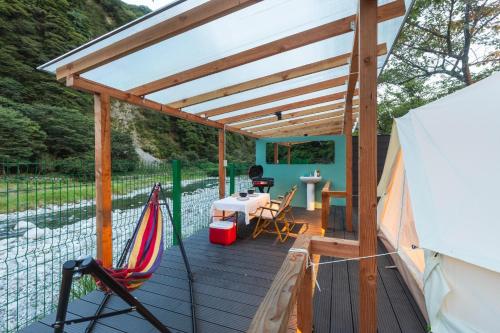Oyama的住宿－SPRINGS VILLAGE Ashigara-Tanzawa Hot Spring Resort & Glamping - Vacation STAY 42312v，一个带吊床和桌子的甲板