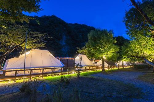 una fila di tende in un campo di notte di SPRINGS VILLAGE Ashigara-Tanzawa Hot Spring Resort & Glamping - Vacation STAY 42312v a Oyama