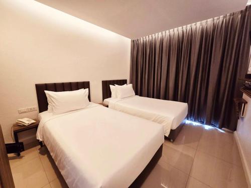 a bedroom with two beds and a window at Red Door Samsen Hotel, Bangkok in Bangkok
