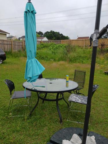 een paraplu op een tafel in een tuin bij Cozy private rooms in Jonesboro