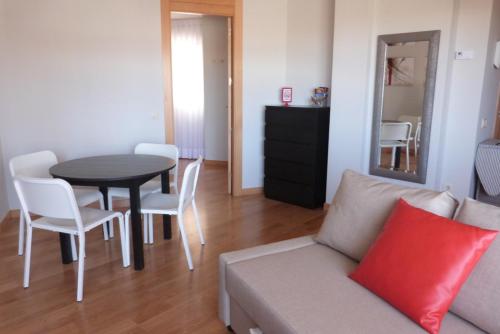 a living room with a couch and a table and chairs at Apartamentos Noluna in Segovia