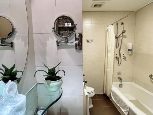 a bathroom with a tub and a toilet and a sink at Chongqing Milky Way Hotel in Chongqing