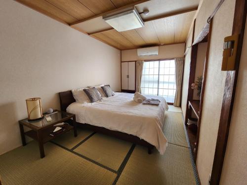 a bedroom with a large bed and a window at Myoko Ski Lodge in Akakura Village in Myoko