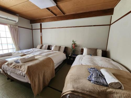 a room with two beds in a room at Myoko Ski Lodge in Akakura Village in Myoko