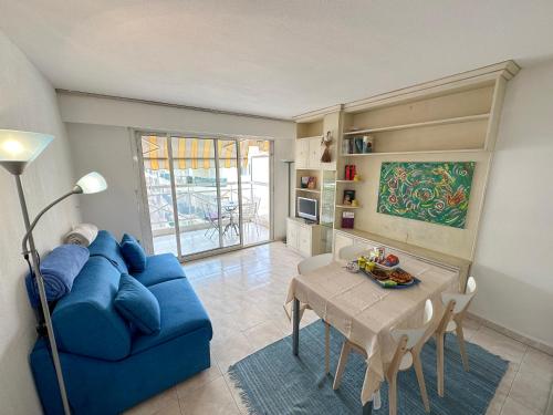 un salon avec un canapé bleu et une table dans l'établissement Charming Apartment in Cannes 10-min to beach, à Cannes