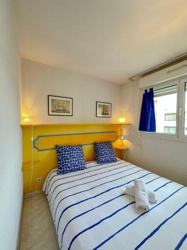 une chambre avec un grand lit avec des draps bleus et blancs dans l'établissement Charming Apartment in Cannes 10-min to beach, à Cannes
