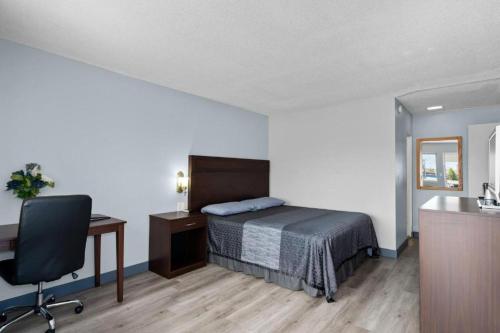 a bedroom with a bed and a desk and a chair at Holiday Lodge in Wenatchee
