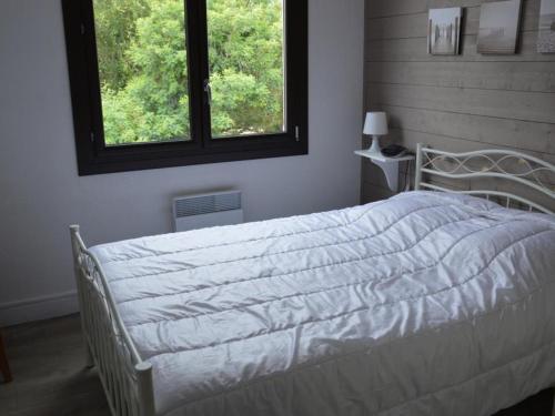 - un lit blanc dans une chambre avec 2 fenêtres dans l'établissement Maison 5 Couchages, 100m Plage, Parking, Jardin, Saint Jean de Monts - FR-1-323-540, à Saint-Jean-de-Monts
