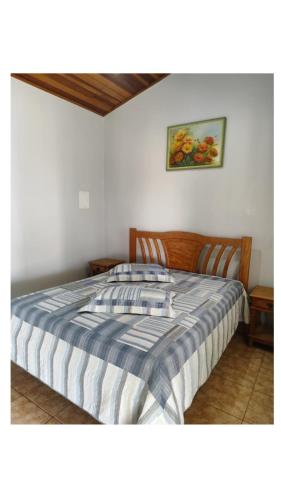 a bedroom with a bed with a striped comforter at Condomínio nogueira 2 in São João Batista do Glória