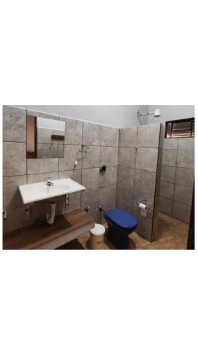 a bathroom with a sink and a blue toilet at Condomínio nogueira 2 in São João Batista do Glória
