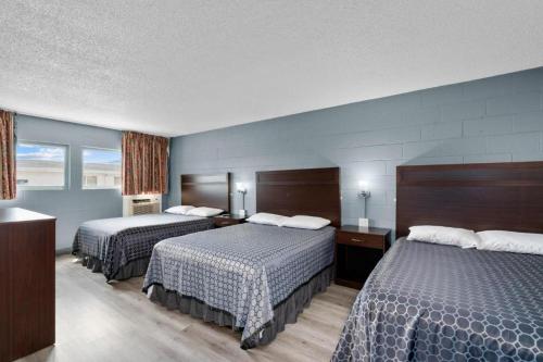 Holiday Lodge في ويناتشي: غرفه فندقيه سريرين في غرفه