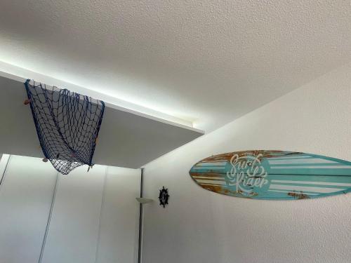 un plafond avec une planche de surf et un panneau dessus dans l'établissement Charmant T2 rénové à 50m de la plage, terrasse OUEST, près des commerces - FR-1-748-24, à Canet