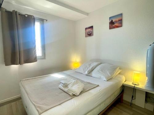 une chambre avec un lit avec deux serviettes dessus dans l'établissement Charmant T2 rénové à 50m de la plage, terrasse OUEST, près des commerces - FR-1-748-24, à Canet