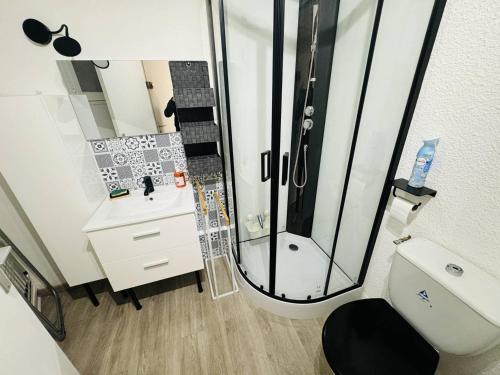 La salle de bains est pourvue d'une douche et de toilettes blanches. dans l'établissement Appartement rénové près du port avec parking privatif - FR-1-723-156, au Cap d'Agde