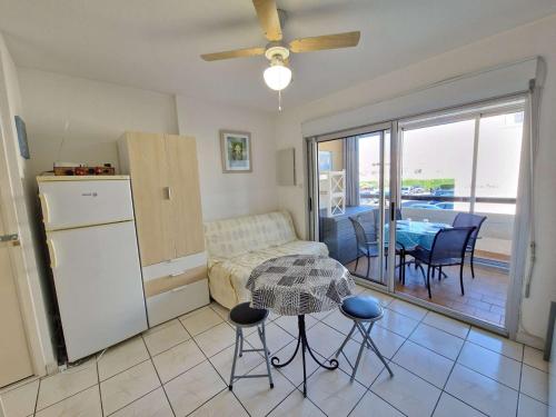 un salon avec un canapé et une table avec des chaises dans l'établissement Studio Cabine avec Piscine, Terrasse et Parking, Proche Commodités - FR-1-387-206, à Marseillan