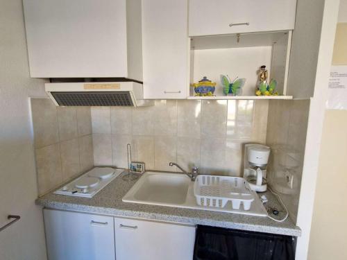 une cuisine avec un évier et un plan de travail dans l'établissement Studio Cabine avec Piscine, Terrasse et Parking, Proche Commodités - FR-1-387-206, à Marseillan