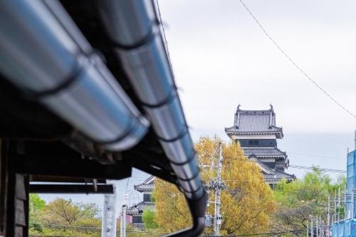 a view of a building from a bus at Hostel みんか松本 in Matsumoto