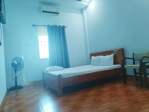 a bedroom with a bed with a fan and a window at Nhà nghỉ thảo ngân in Bình Mỹ