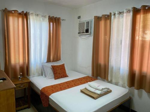um pequeno quarto com uma cama com toalhas em MKB Pension em Coron