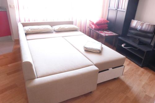 a large white bed in a room with a television at Apartamentos Noluna in Segovia