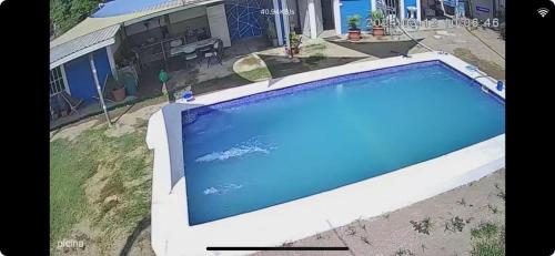 una grande piscina blu di fronte a una casa di Rancho la potranca sv 