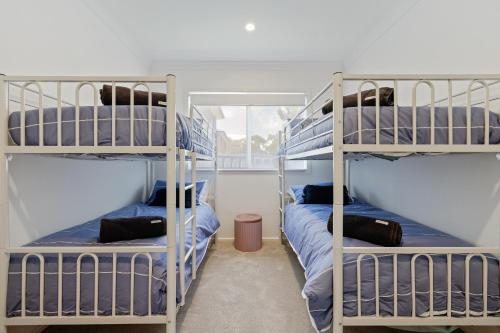 two bunk beds in a room with a window at Cowes Family Beach House in Cowes
