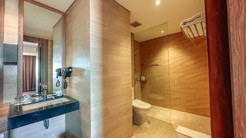 a bathroom with a toilet and a sink and a shower at Swiss-Belinn Karawang in Karawang