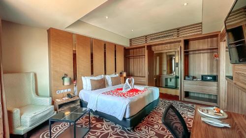 ein Schlafzimmer mit einem Bett und einem Stuhl in einem Zimmer in der Unterkunft Swiss-Belinn Karawang in Karawang