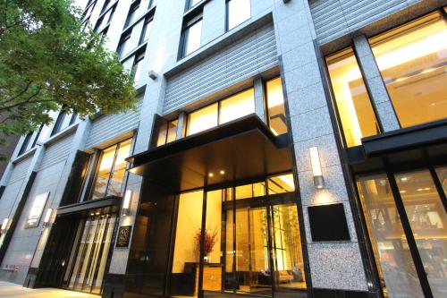 a building with large windows on a city street at KOKO HOTEL Premier Kanazawa Korinbo in Kanazawa