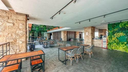 a restaurant with wooden tables and chairs in a room at Swiss-Belinn Karawang in Karawang