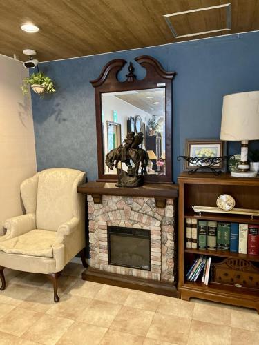 a living room with a fireplace and a mirror at Hotel Hanaya in Tanabe
