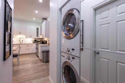 una cucina con lavatrice e asciugatrice accanto a una porta di 5705-Modern 2 BD / fully equipped, near DT MTL a Montréal