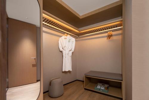 a dressing room with a robe hanging on a wall at Holiday Inn Quzhou, an IHG Hotel in Quzhou