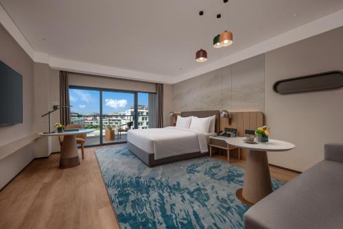 um quarto de hotel com uma cama e uma grande janela em Holiday Inn Quzhou, an IHG Hotel em Quzhou