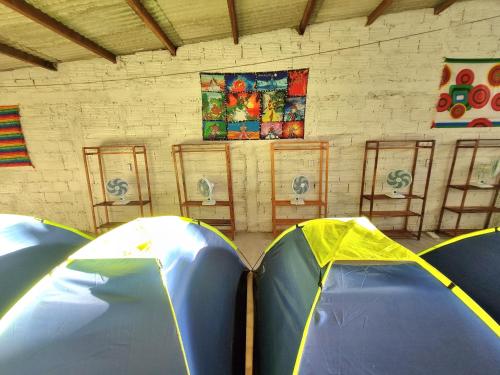 two tents in a room with paintings on the wall at Jurema Camping in Itacaré