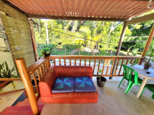 a screened in porch with a red couch and a table at Jurema Camping in Itacaré