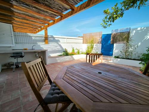 a wooden table and chairs on a patio at 26 Casa dos Miúdos - Alfarim in Sesimbra