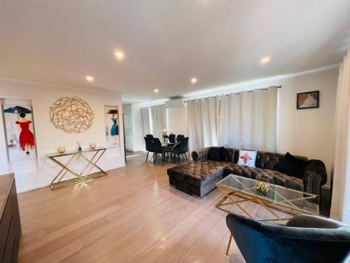 a living room with a couch and a table at Matuhi Deluxe 2 bedrooms unit in Auckland