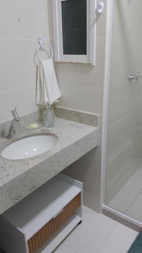 a bathroom with a sink and a shower at Golden Lake Apart Hotel Arraial do Cabo RJ A&J 2 in Arraial do Cabo