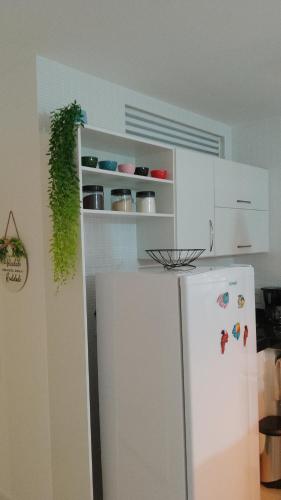 a kitchen with a white refrigerator and white cabinets at Golden Lake Apart Hotel Arraial do Cabo RJ A&J 2 in Arraial do Cabo