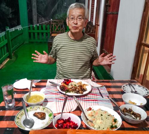 a man sitting at a table with plates of food at Jm Resort in Dambulla