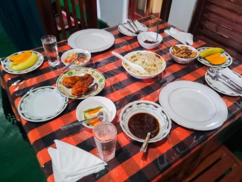 uma mesa com pratos de comida numa toalha de mesa xadrez em Jm Resort em Dambulla