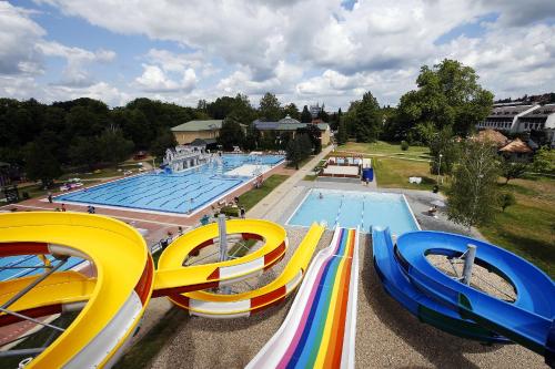 a large swimming pool with a slide in front of it at Nemes Apartman in Eger
