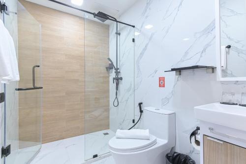 a bathroom with a shower and a toilet and a sink at Shewin de Bangkok in Ban Bang Bamru