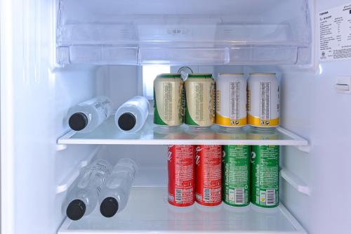 a refrigerator filled with lots of soda cans at Shewin de Bangkok in Ban Bang Bamru