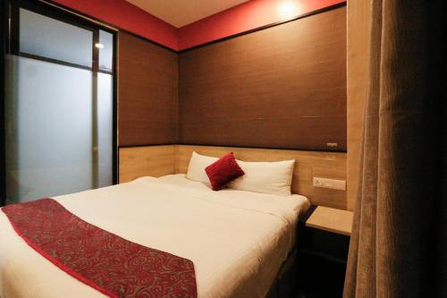 a bedroom with a bed with a red pillow on it at Golden Roof Hotel, Seri Iskandar in Seri Iskandar
